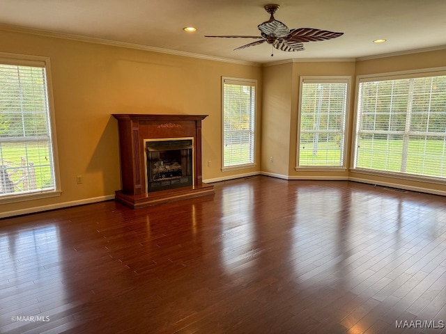 unfurnished living room with dark hardwood / wood-style flooring, a wealth of natural light, and crown molding