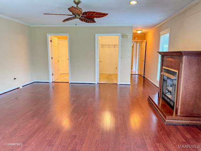 unfurnished living room featuring ornamental molding, ceiling fan, and dark wood-type flooring