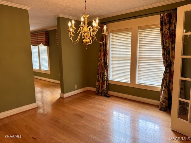 spare room featuring hardwood / wood-style flooring, ornamental molding, and a wealth of natural light