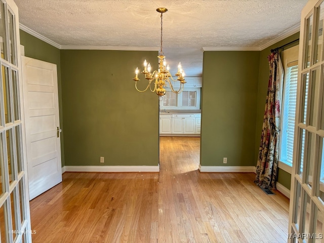 interior space featuring a chandelier, crown molding, light hardwood / wood-style floors, and a textured ceiling