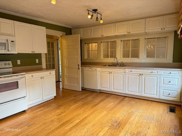 kitchen featuring a textured ceiling, white appliances, sink, light hardwood / wood-style flooring, and white cabinetry