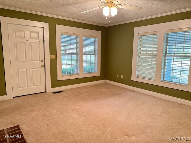 entrance foyer with a textured ceiling, light colored carpet, ceiling fan, and ornamental molding