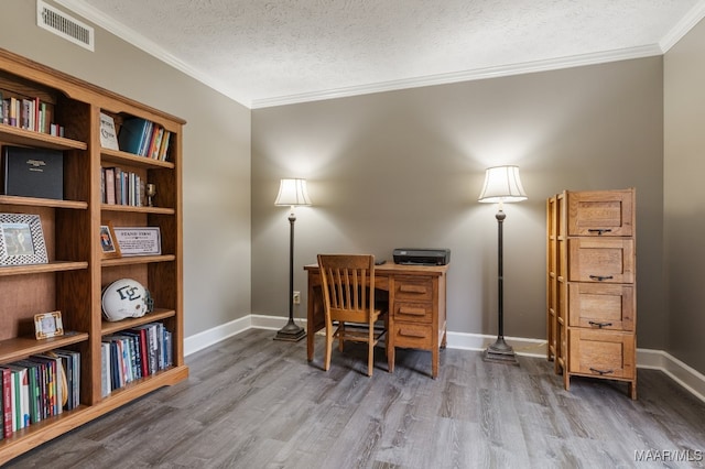 home office with a textured ceiling, wood-type flooring, and ornamental molding