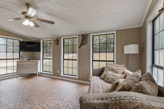 unfurnished living room with a textured ceiling, a healthy amount of sunlight, ceiling fan, and vaulted ceiling