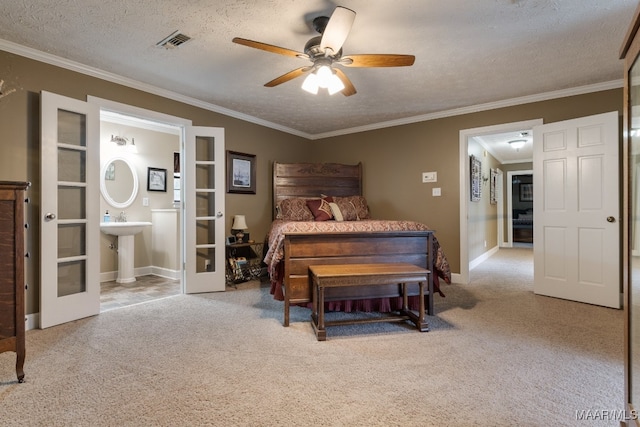 carpeted bedroom with french doors, ornamental molding, a textured ceiling, ensuite bathroom, and ceiling fan