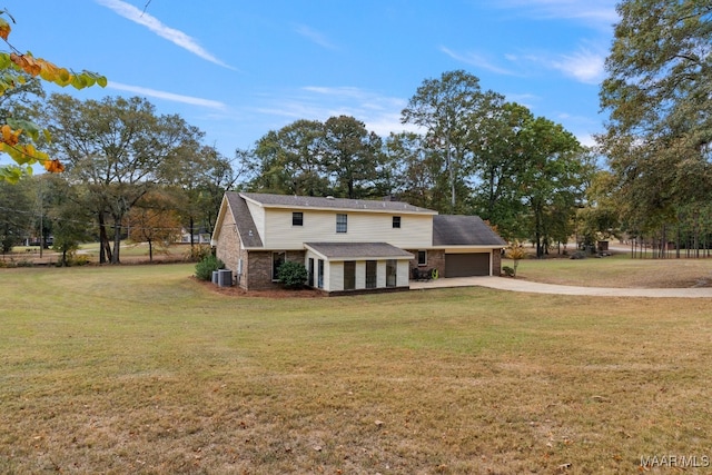 view of front of property with a front yard, central AC, and a garage