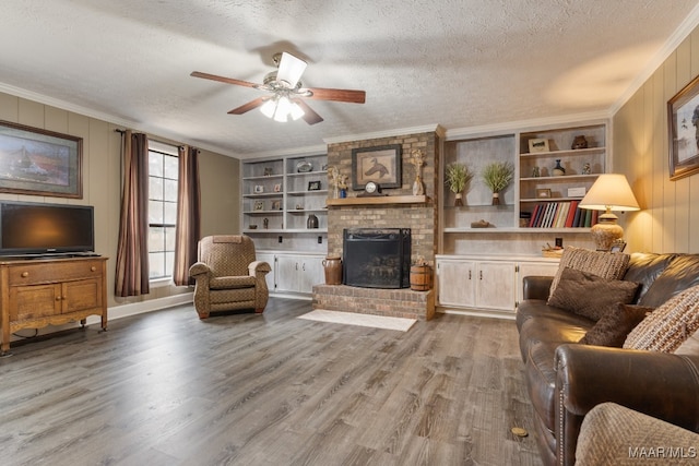 living room featuring ornamental molding, hardwood / wood-style floors, a brick fireplace, and a textured ceiling