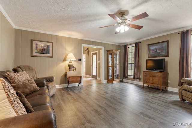 living room with ornamental molding, hardwood / wood-style floors, a textured ceiling, and ceiling fan