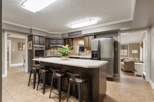 kitchen with backsplash, a textured ceiling, dark brown cabinetry, light tile patterned floors, and stainless steel refrigerator with ice dispenser