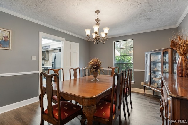 dining area featuring dark wood-type flooring, crown molding, a notable chandelier, and a textured ceiling