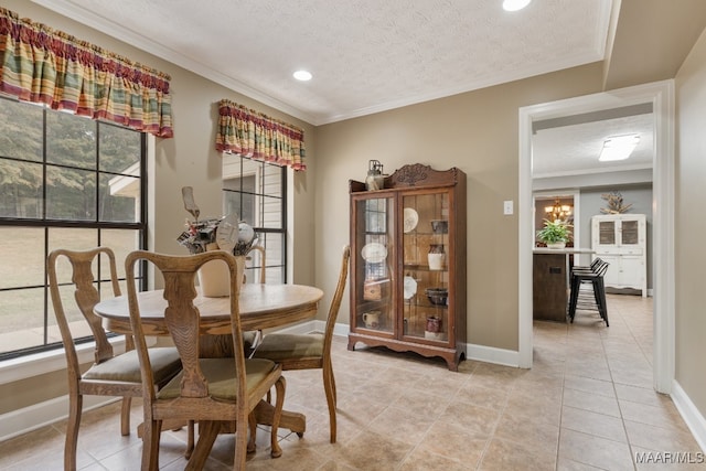 dining space featuring a notable chandelier, a textured ceiling, light tile patterned floors, and ornamental molding