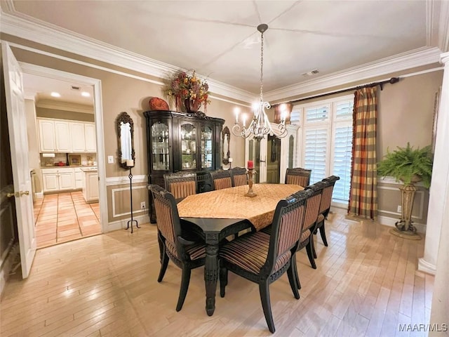 dining space featuring ornamental molding, a chandelier, and light wood-type flooring