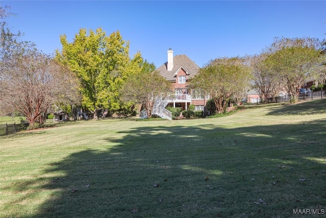 view of yard with fence and stairway