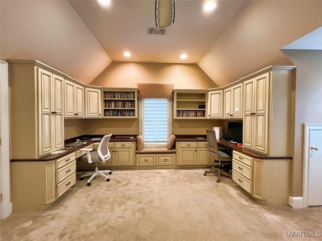 carpeted home office featuring built in desk and vaulted ceiling