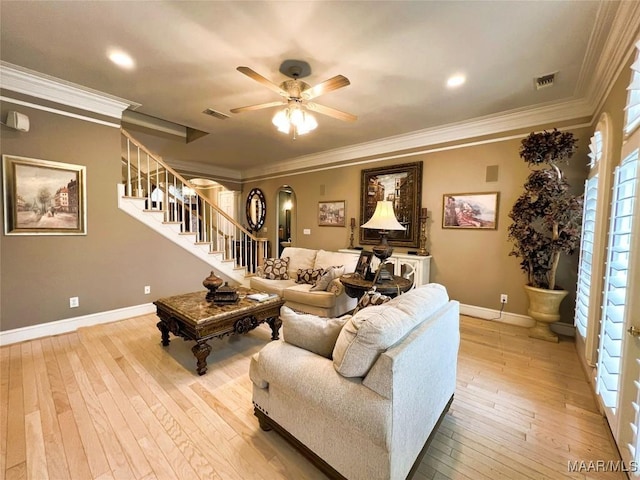 living room with light hardwood / wood-style flooring, ornamental molding, and ceiling fan