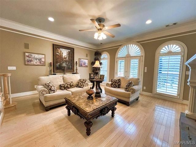 living room featuring visible vents, crown molding, light wood-style flooring, and baseboards