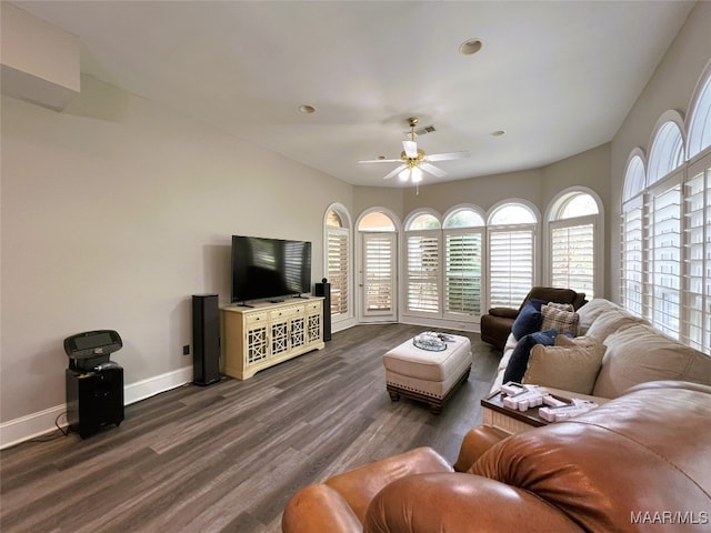 living area featuring dark wood-style floors, visible vents, baseboards, and a ceiling fan