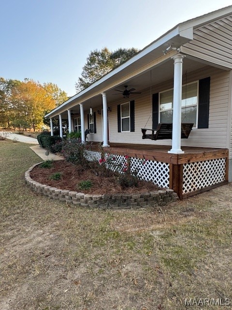 view of property exterior with covered porch and ceiling fan