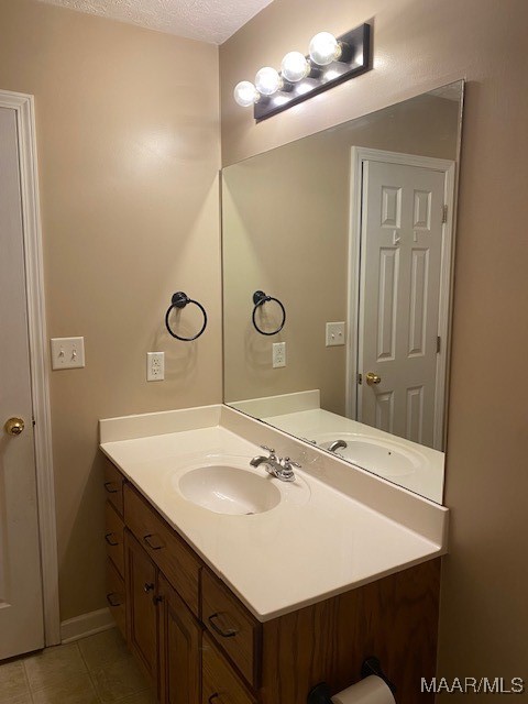 bathroom with vanity, a textured ceiling, and tile patterned floors