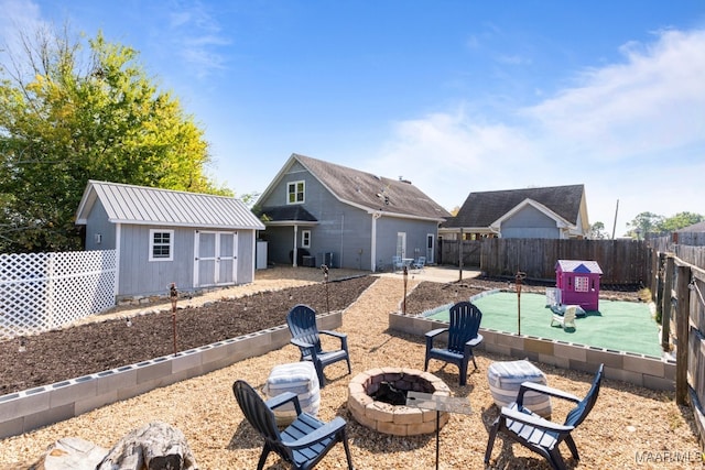 back of property featuring a storage unit and a fire pit