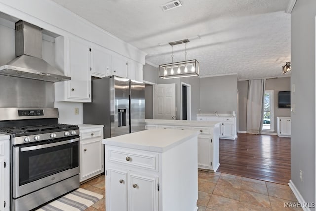 kitchen with stainless steel appliances, pendant lighting, light hardwood / wood-style floors, wall chimney exhaust hood, and a center island