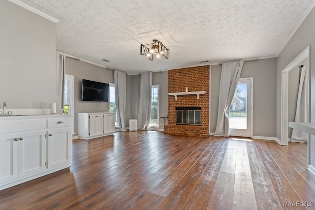 unfurnished living room featuring a wealth of natural light, a fireplace, and dark hardwood / wood-style flooring