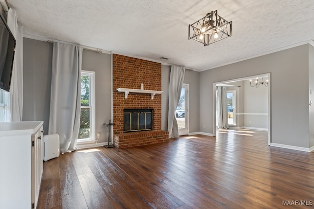 unfurnished living room with a textured ceiling, dark hardwood / wood-style flooring, a brick fireplace, radiator heating unit, and ornamental molding