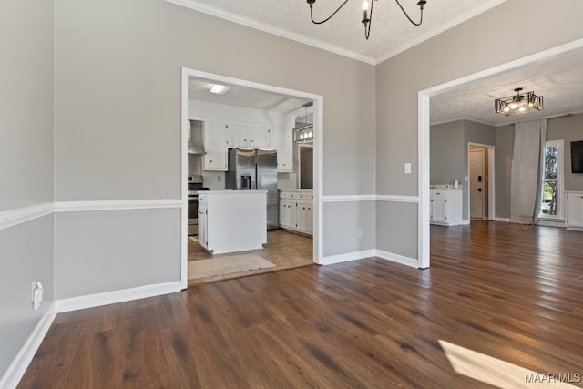 spare room with ornamental molding, a notable chandelier, a textured ceiling, and dark hardwood / wood-style flooring