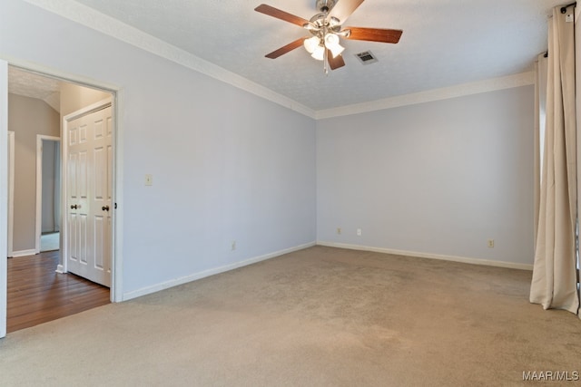 carpeted empty room with ceiling fan and a textured ceiling