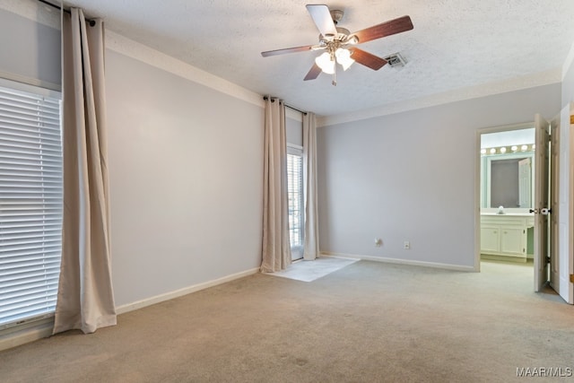 spare room featuring ceiling fan, a textured ceiling, and light colored carpet