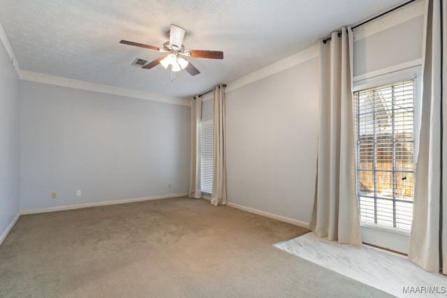 spare room featuring ornamental molding, light carpet, a textured ceiling, and ceiling fan