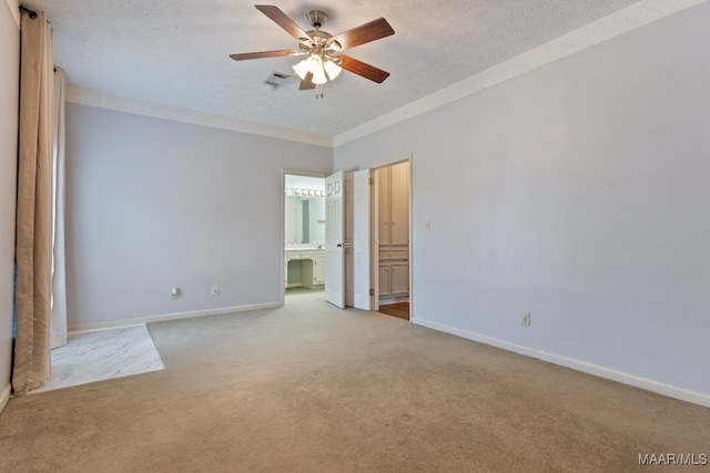 spare room with ceiling fan, a textured ceiling, and light colored carpet