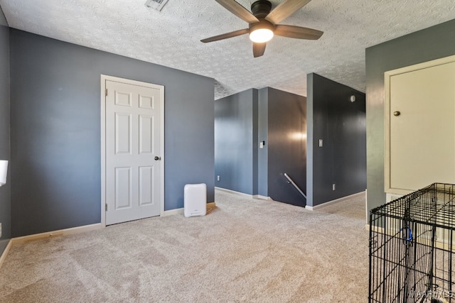 unfurnished room featuring carpet, a textured ceiling, and ceiling fan