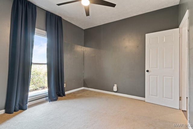 carpeted spare room featuring ceiling fan and a textured ceiling