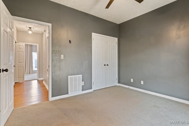 unfurnished bedroom with light hardwood / wood-style floors, a textured ceiling, and ceiling fan