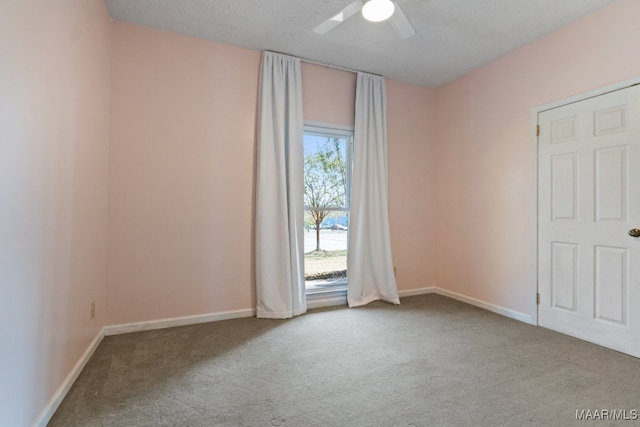 carpeted spare room with a textured ceiling and ceiling fan