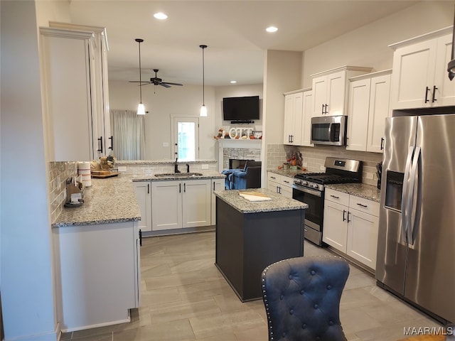 kitchen with a center island, white cabinets, hanging light fixtures, kitchen peninsula, and stainless steel appliances