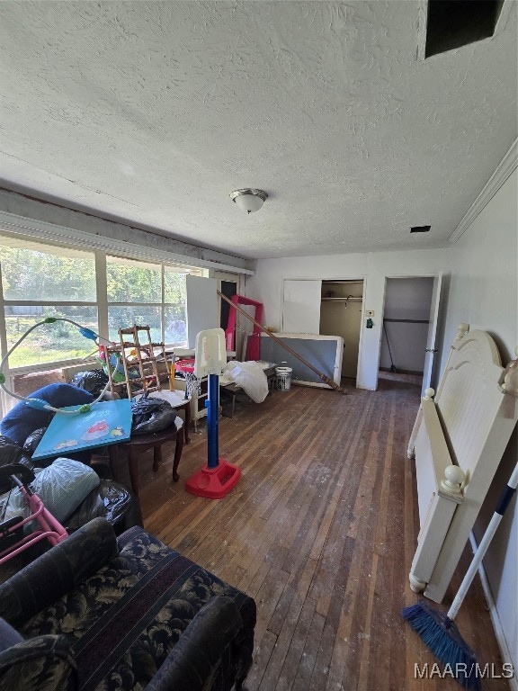 living room with ornamental molding, a textured ceiling, and wood-type flooring