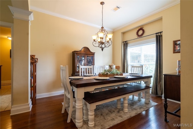 dining room with crown molding, ornate columns, dark wood-type flooring, and an inviting chandelier