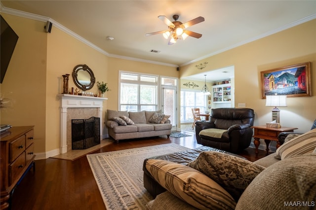 living room featuring a high end fireplace, dark hardwood / wood-style floors, ceiling fan, and crown molding