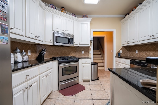 kitchen featuring appliances with stainless steel finishes, backsplash, ornamental molding, light tile patterned floors, and white cabinets