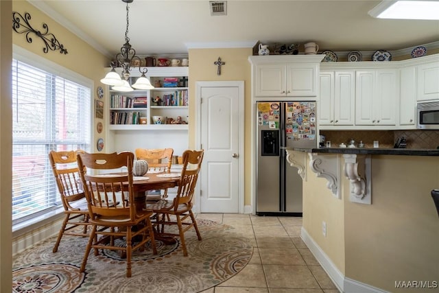 5612 New Harvest Dr, Montgomery, AL 36116 - kitchen featuring appliances with stainless steel finishes, hanging light fixtures, light tile patterned flooring, dark countertops, and a chandelier