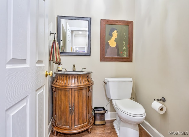 bathroom featuring vanity, hardwood / wood-style flooring, and toilet