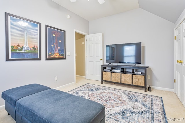 carpeted living room with ceiling fan and vaulted ceiling