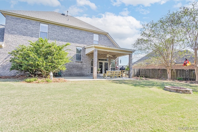 back of house with a patio area, an outdoor fire pit, a lawn, and ceiling fan