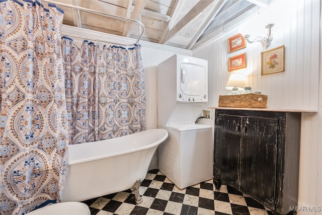 bathroom with stacked washer and dryer and a tub