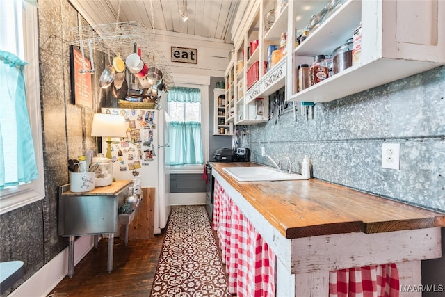 kitchen featuring wood ceiling, dark hardwood / wood-style floors, butcher block counters, white fridge, and sink