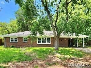 back of house with a carport and a lawn