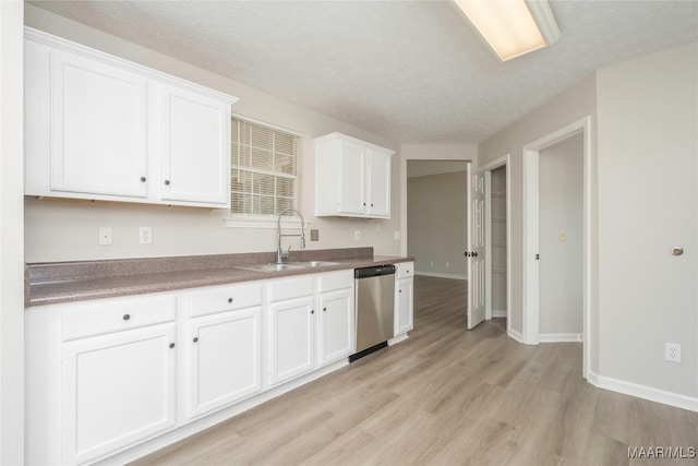 kitchen with white cabinetry, stainless steel dishwasher, and light wood-type flooring