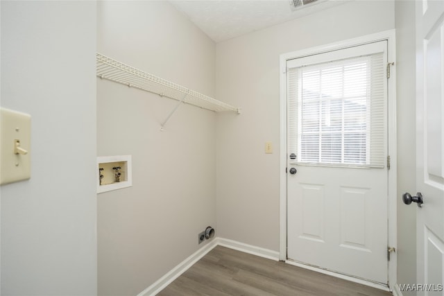 laundry area with a textured ceiling, hardwood / wood-style flooring, and washer hookup